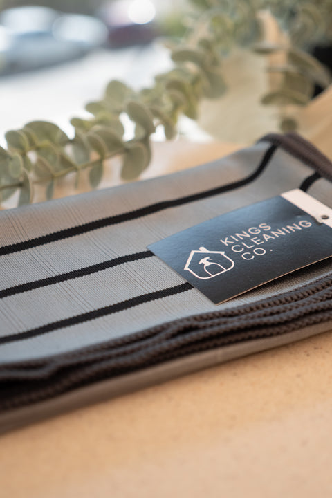 A grey and black striped Glass microfiber cloth, folded on a bench top